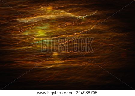 Abstract background of blurred yellow lines in motion similar to sunset haze. Bokeh of defocused crankles, blurred neon leds, shimmering and glare lights of sunbeams through clouds