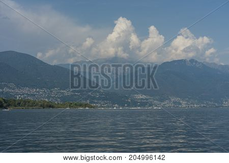 lago maggiore lake scenery with mountain water and cloudy sky in summer from boat