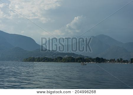 lago maggiore lake scenery with mountain water and cloudy sky in summer from boat