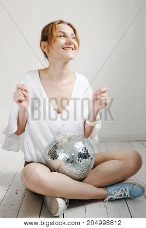 Young Hipster Woman Holding Disco Ball And Posing Cheerfully On White Background