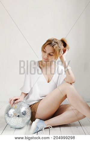 Young Hipster Woman Holding Disco Ball And Posing Cheerfully On White Background