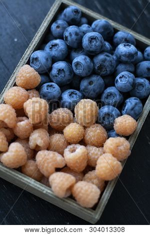 A Tasty And Healthy Snack: A Box Of Raspberries And Blueberries.
