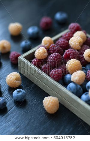 A Tasty And Healthy Snack: A Box Of Raspberries And Blueberries.