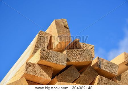 Stacked Lumber On Blue Sky.folded Wood.closeup Wooden Boards.the Surface Of The End Of The Board.lot