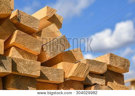 Stacked Lumber On Blue Sky.folded Wood.closeup Wooden Boards.the Surface Of The End Of The Board.lot