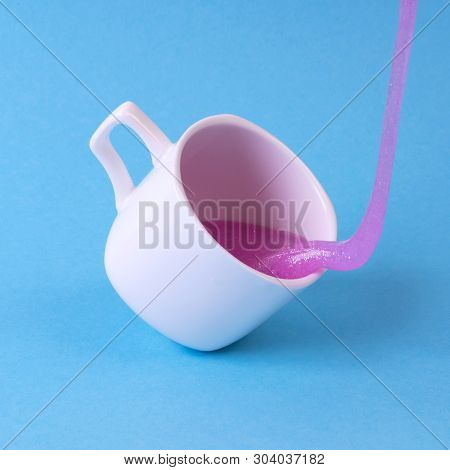 Bright Pink Glitter Slime Comes In Mug. White Cup On Blue Background. Art Neon Surrealism And Minima
