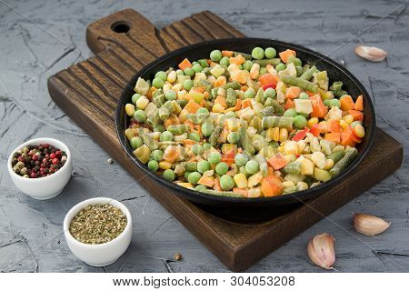 Frozen Chopped Vegetables In A Boiling Pan With Spices. Vegan Food.