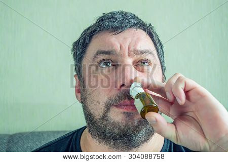 Man With Runny Nose Treats Nose With Nasal Spra