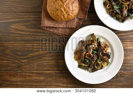 Tasty Fried Beef Liver With Onion On Plate Over Wooden Background With Copy Space. Pieces Cooked Liv