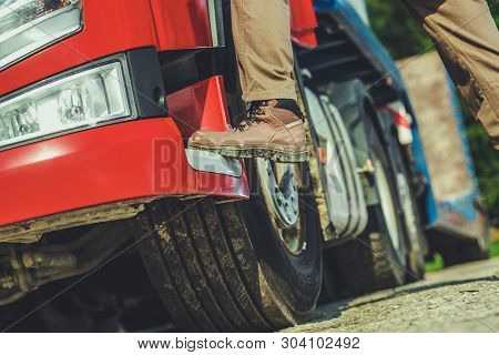 Truck Driver And His Job Conceptual Photo Of Men Getting Into Semi Truck. Leg Closeup. Transportatio