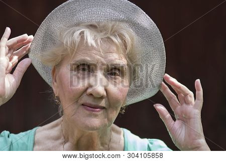 Senior Female Posing Outdoor With A Hat On Her Head, Hed And Shoulders Portrait