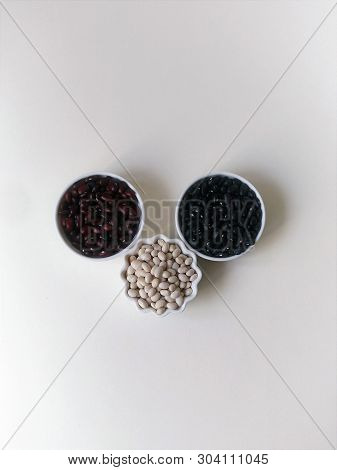 Layout Three Bowls Of White, Red And Black Beans On A White Background