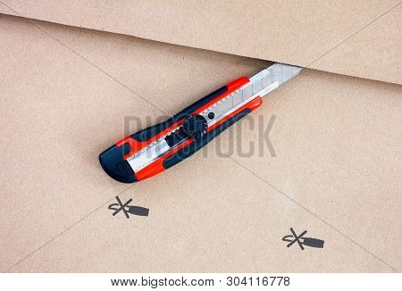 Paper Knife On Cardboard With Do Not Open With A Knife Sign. Close-up.