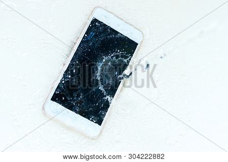 Phone Dropped Into The Water. Telephone And Water Spra