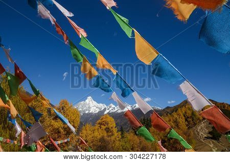 Colorful Tibetan Flags And Snow Mountain At Siguniang Scenic Area In Autumn Season,chengdu, China.
