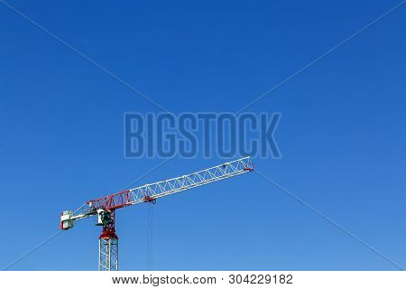 Industrial Construction Crane Or Column-jib Crane With Cabin Works  On The Construction Site And Blu