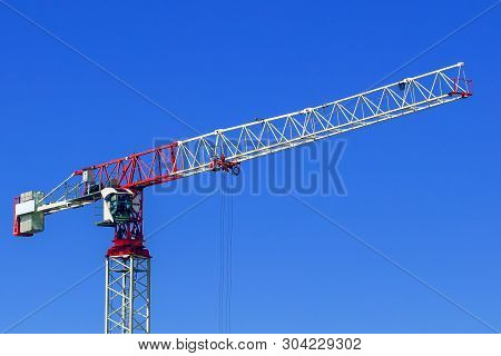 Industrial Construction Crane Or Column-jib Crane With Cabin Works  On The Construction Site And Blu