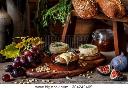 Soft Spreadable French Stinky Cheese On A Slice Of Bread With Fruit And Pine Nuts