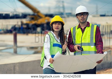 Foreman 3 people are sitting to see a blueprint about the factory building structure on the job site
