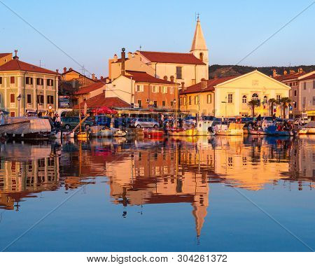 Izola, Slovenia - May 1, 2019: Scenic Harbour With Boats And Brightly Coloured Houses On The Sunset 