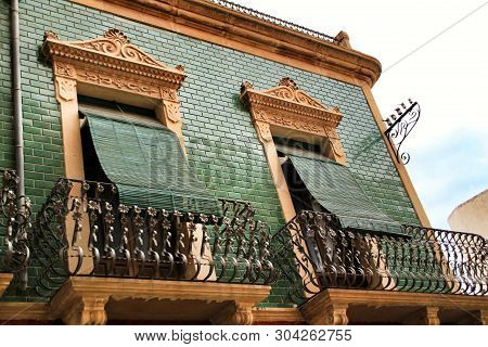 Old Colorful And Majestic Tiled Facades With Vintage Streetlight In Elche, Alicante, Spain. El Raval