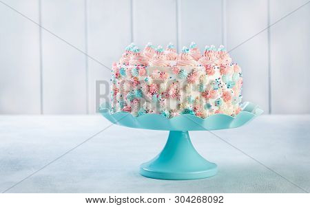 Vanilla Buttercream Birthday Cake With Colorful Sprinkles Over A Neutral Background.