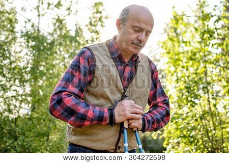 Senior Man Nordic Resting After Nordic Walking In Park.