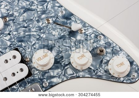 Close Up Three Controls On  White Electric Guitar, Studio Shoot. Black Pearl Pickguard, Volume X 1, 