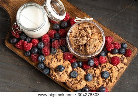Biscuits And Mixed Forest Fruits Placed On Wooden Board.