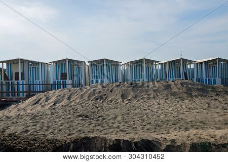 Striped White And Blue Striped Beach Houses And Black Sandy Beach, Tyrrhenian Sea Near Roma, Italy