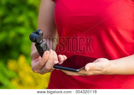 Close Up Picture Of Osmo Camera And Smart Phone In Female Hands