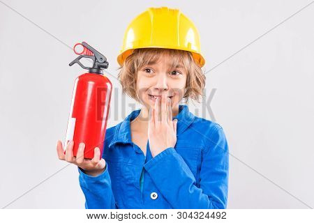 Emotional Portrait Of Attractive Caucasian Girl Wearing Safety Yellow Hard Hat. Beautiful Child Hold