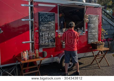 Victoria, Vancouver Island, British Columbia, Canada, July, 8, 2019: A Man In A Red Shirt Ordering F