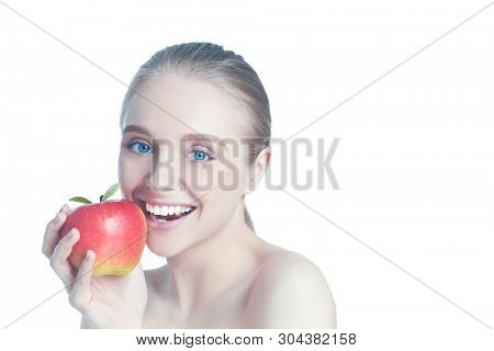 Portrait of happy smiling young beautiful woman eating red apple, over white background