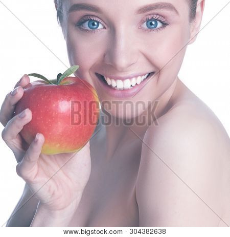 Portrait of happy smiling young beautiful woman eating red apple, over white background