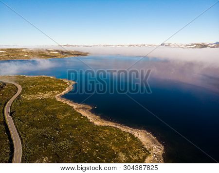 Aerial View. Road Crossing Hardangervidda Mountain Plateau, Clouds Over Lakes, Morning Time. Norway 