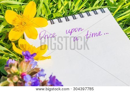 Notepad Is Lying On The Green Grass. Summer Bright Sunny Cozy Still Life. The Inscription On The Not