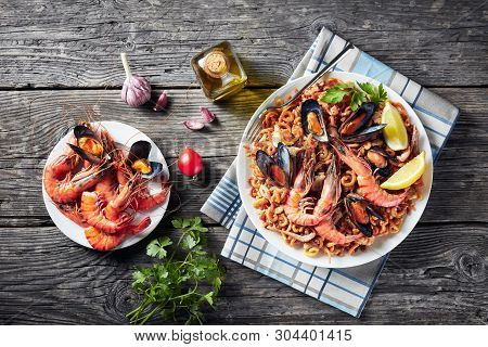 Spanish Fideua, A Noodle Paella With King Prawns, White Fish Meat, Calamari, Mussels Served On A Whi