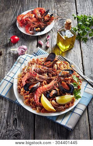 Spanish Fideua, A Noodle Paella With King Prawns, White Fish Meat, Calamari, Mussels Served On A Whi