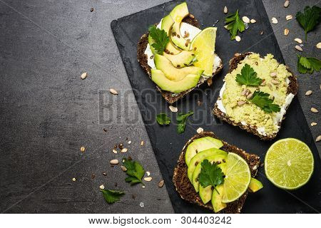 Avocado Sandwich With Seeds And Cream Cheese. Black Slate Background, Top View.