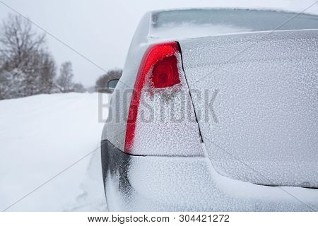 View Focused On The Back Red Tail Lights Of Car  And Car Trunk  Or Car Boot   On Winter Road Covered