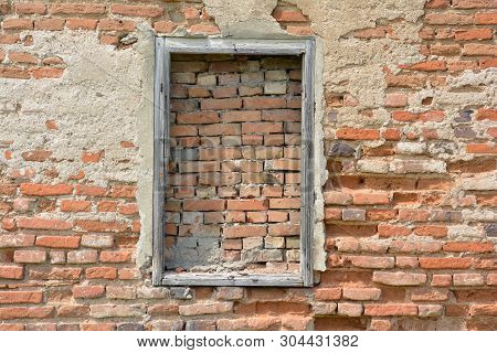A Bricked Window With Wooden Frame On The Wall Of Red Brick.