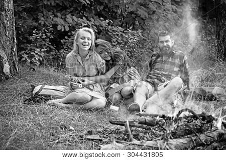 Bearded Man And Women Smile At Bonfire. Happy Friends At Campfire. Hipster In Palid Shirt And Girls 