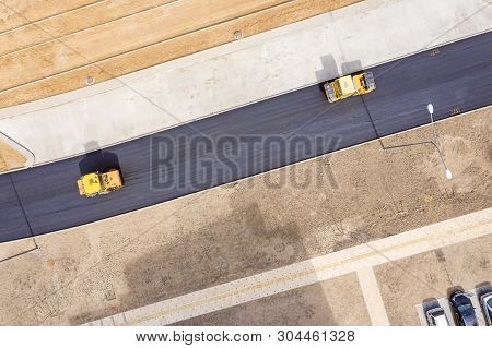 Steam Road Rollers Leveling New Asphalt On Road. Birds Eye View