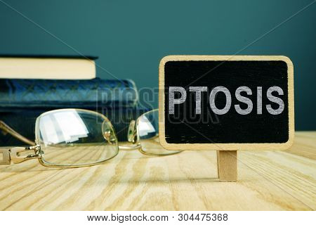 Ptosis Disease. Eye Glasses And Book On Desk.