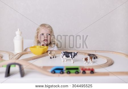 Little Cute Baby Boy (3 Years Old) Drinks Milk With Cookies And Plays In The Wooden Station Train Se