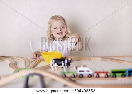 Little Cute Baby Boy (3 Years Old) Drinks Milk With Cookies And Plays In The Wooden Station Train Se