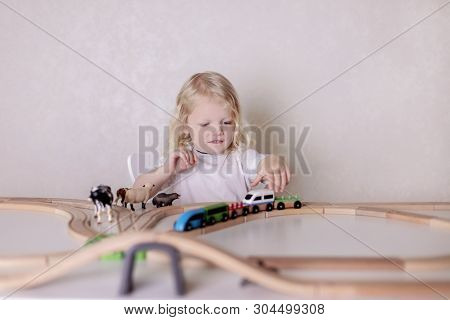 Little Cute Baby Boy (3 Years Old) Drinks Milk With Cookies And Plays In The Wooden Station Train Se