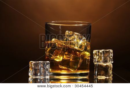 verre de whisky et de la glace sur fond marron