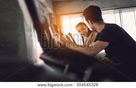 Young People - Group Of Women And Men - Doing Sport Biking In The Gym For Fitness. Young Woman Worko